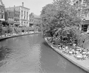 881079 Gezocht op de Oudegracht te Utrecht, vanaf de Bakkerbrug, met terrasjes op de werven.